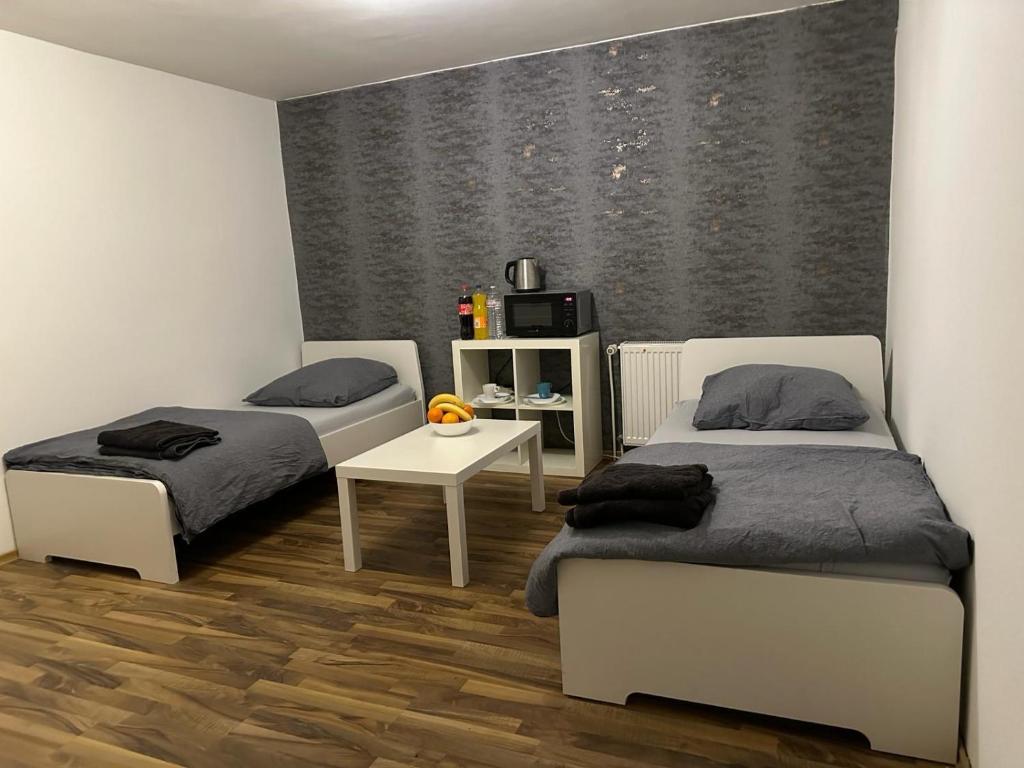 a room with two beds and a table in it at Fair apartment 2 in Kelsterbach