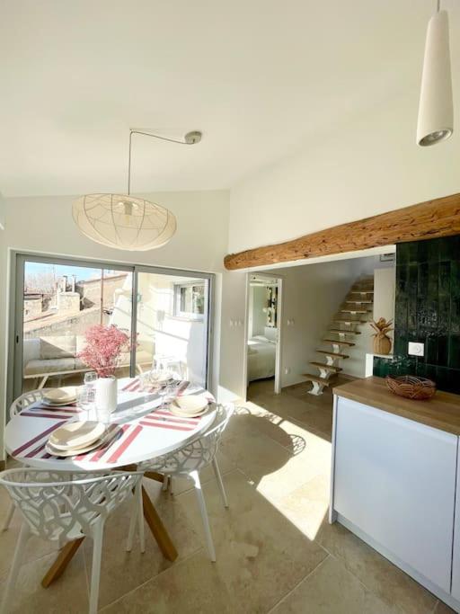 une cuisine et une salle à manger avec une table et un escalier dans l'établissement Magnifique appartement + terrasse au cœur d’Aix, à Aix-en-Provence