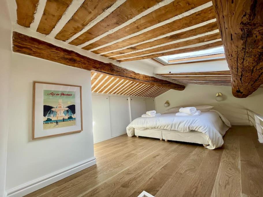 a bedroom with a bed and a wooden ceiling at Magnifique appartement + terrasse au cœur d’Aix in Aix-en-Provence