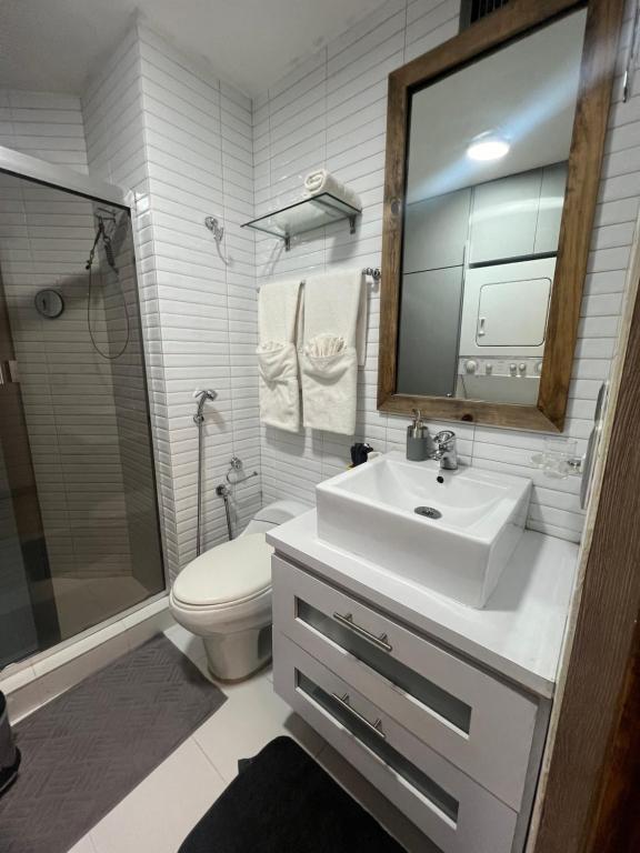 uma casa de banho com um lavatório, um WC e um espelho. em Lomas de las Mercedes em Caracas