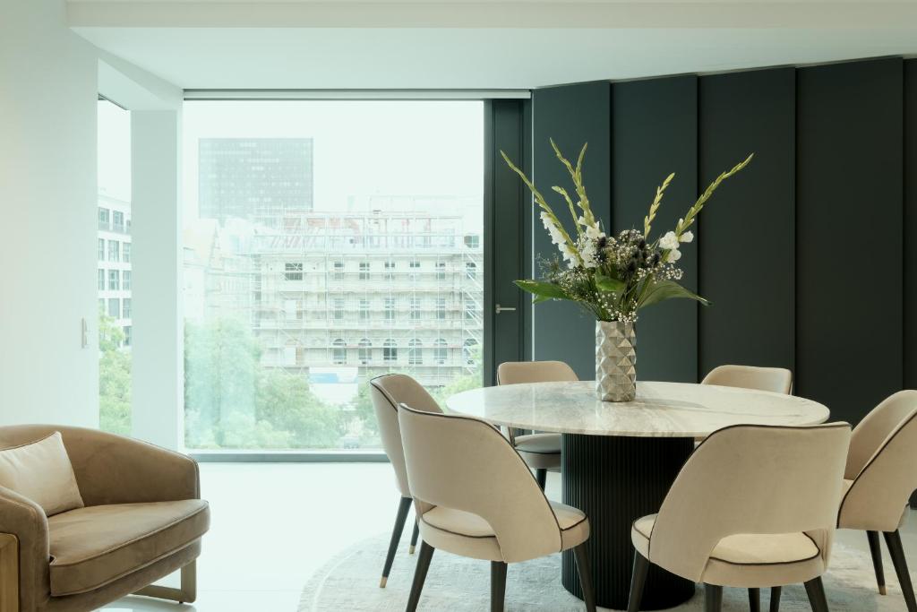 a dining room with a table with chairs and a vase of flowers at Lux.41 in Berlin