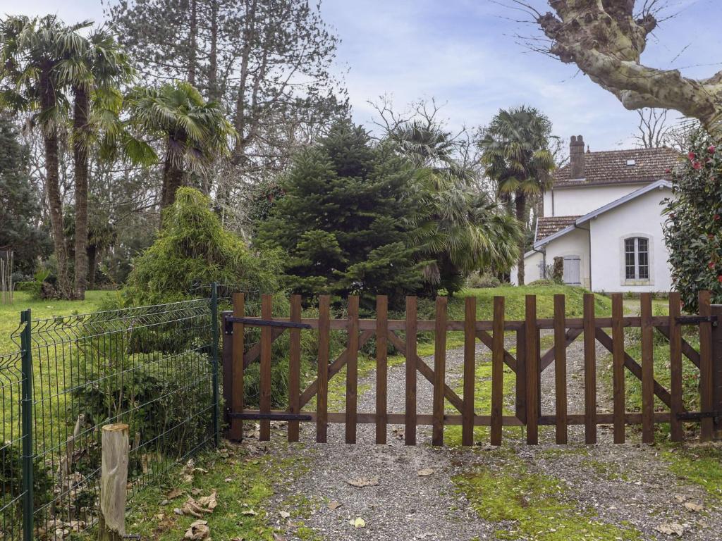 a wooden fence in front of a house at Holiday Home Le chant des milans by Interhome in Ondres