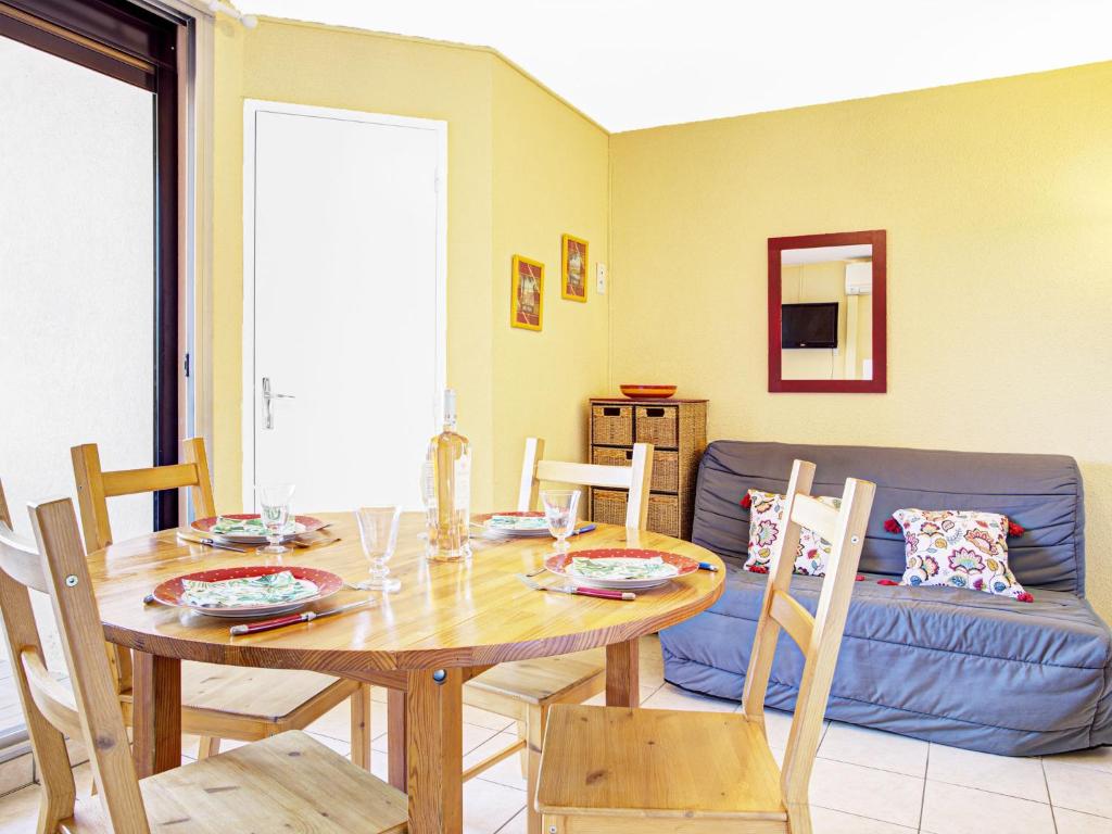 a dining room with a table and a couch at Apartment Les Coraux-3 by Interhome in Canet-en-Roussillon