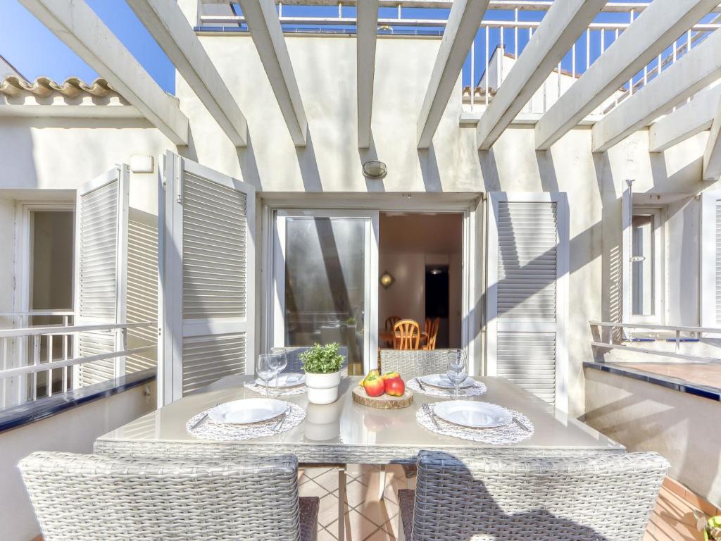 a room with a table and chairs on a balcony at Apartment Platja de Roses-8 by Interhome in Roses