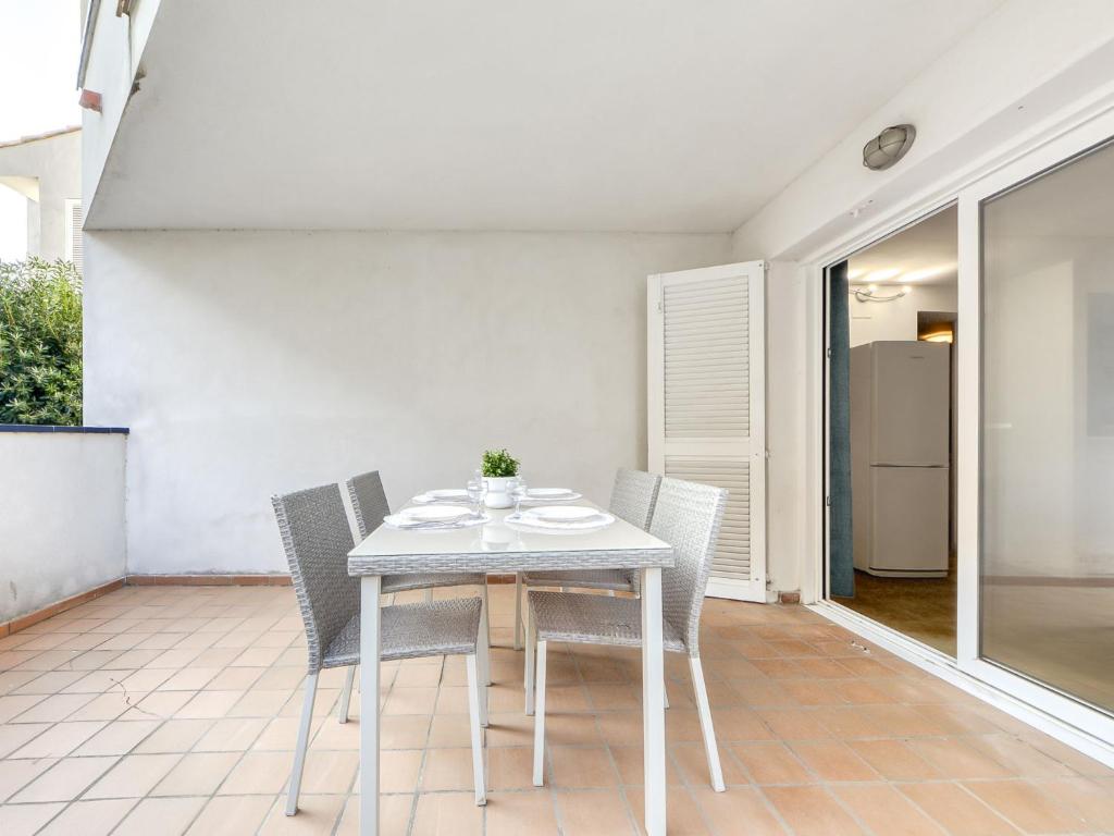 a white table and chairs on a patio at Apartment Platja de Roses-11 by Interhome in Roses