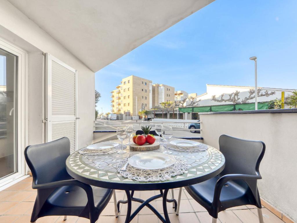 a table with a bowl of fruit on a balcony at Apartment Platja de Roses-9 by Interhome in Roses