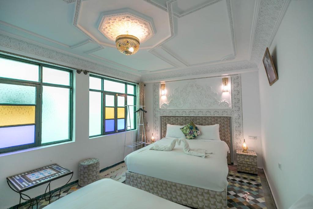 a bedroom with two beds and a ceiling at Riad dar Yamna in Fès