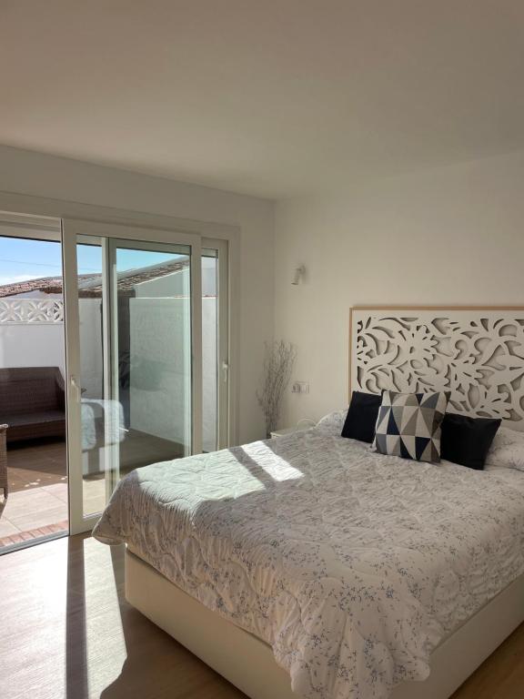 a bedroom with a large bed and a balcony at La Perla del Mar in Estepona