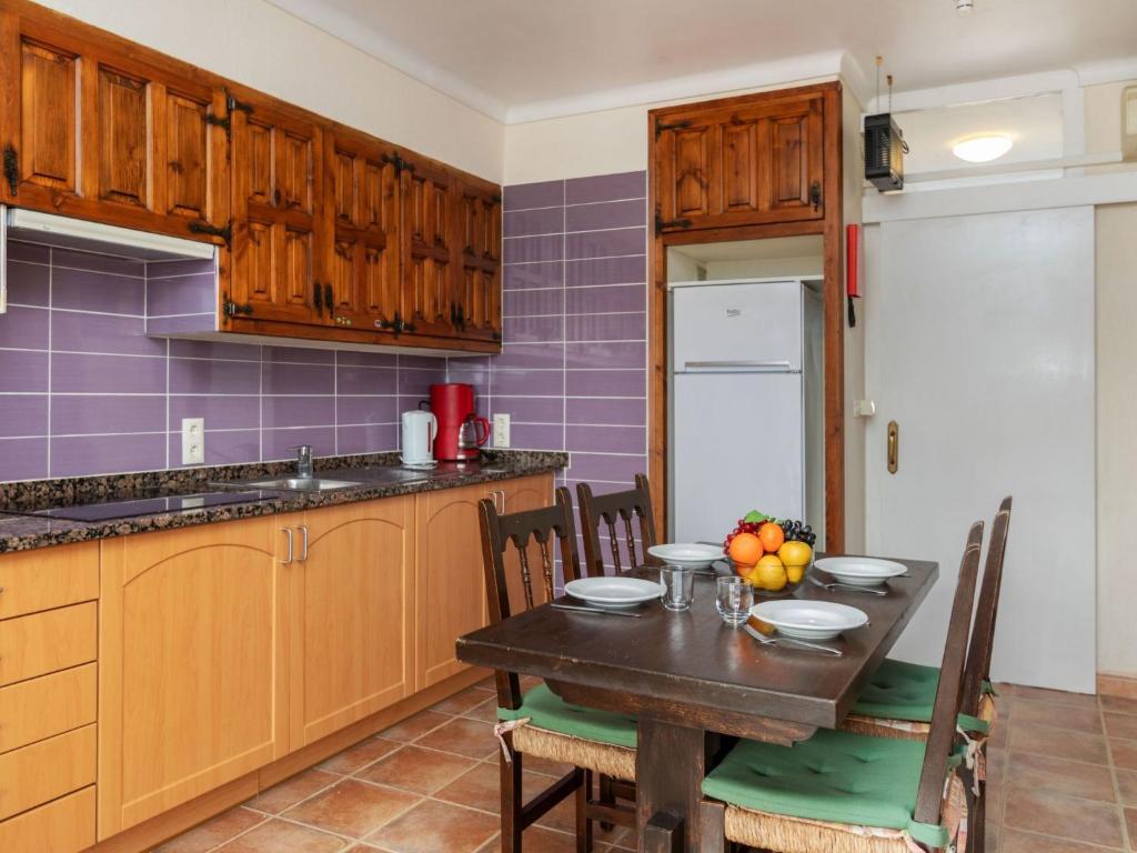 une cuisine avec une table en bois et des chaises ainsi qu'un astérisque dans l'établissement Apartment Anfora 9 by Interhome, à Sant Martí d’Empúries