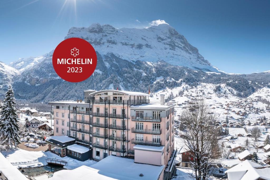 ein Hotel im Schnee mit einem Berg im Hintergrund in der Unterkunft Belvedere Swiss Quality Hotel in Grindelwald