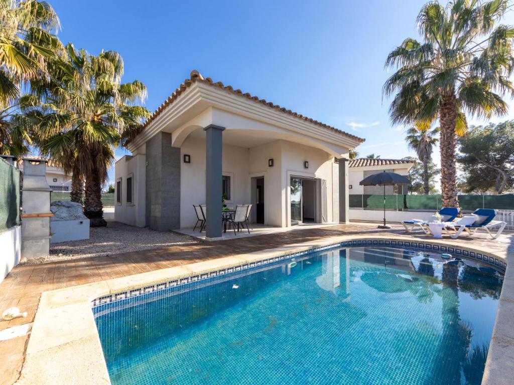 una piscina frente a una casa con palmeras en Holiday Home Gaviota 16 by Interhome, en Riumar