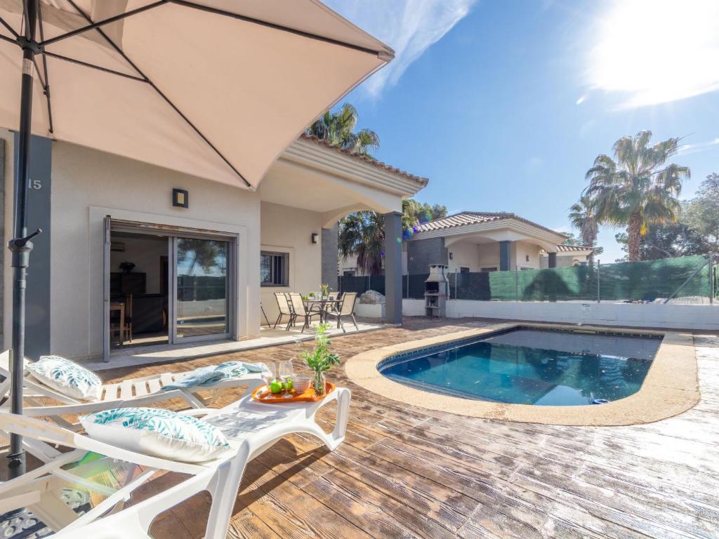 a home with a swimming pool and an umbrella at Holiday Home Gaviota 1 by Interhome in Riumar