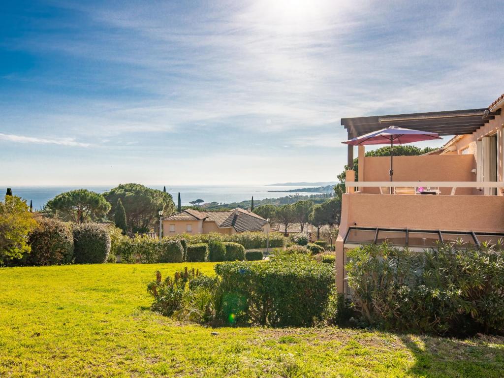 une maison dans un champ avec un parasol dans l'établissement Apartment Les Coteaux de la Nartelle-17 by Interhome, à Sainte-Maxime