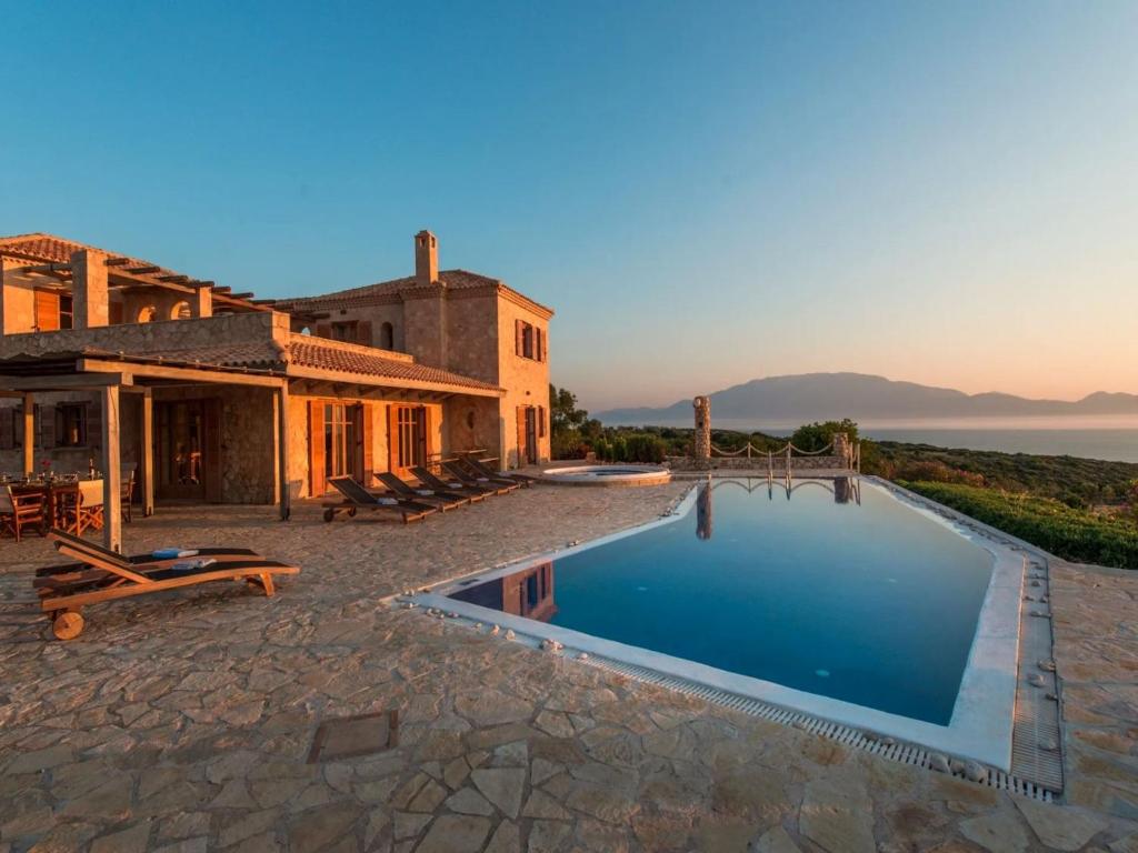 a house with a swimming pool next to a building at Elegant Zante Villa - Villa Divas - 6 Bedrooms - Infinity Pool - 100 Metres To The Sea - Short Drive To Agios Nikolaos in Koríthion