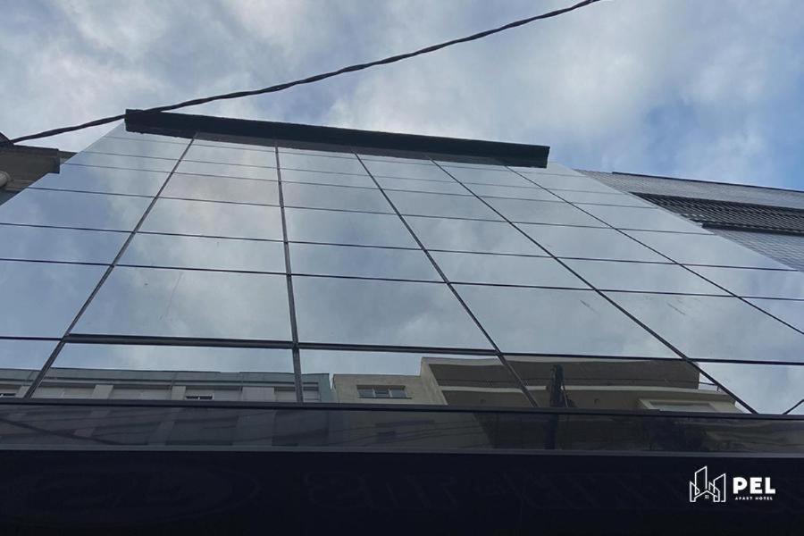 a glass facade of a building reflecting the sky at Pel Apart Hotel in Pelotas
