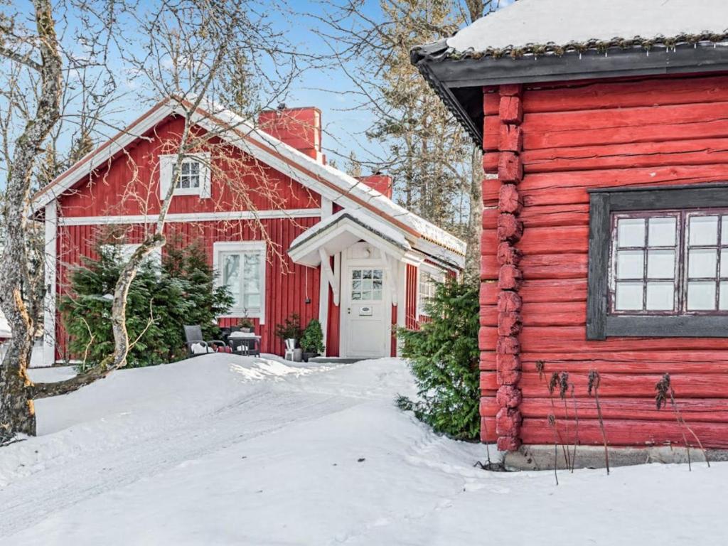 a red house and a red barn in the snow at Holiday Home Isopehtoori by Interhome in Hirsjärvi