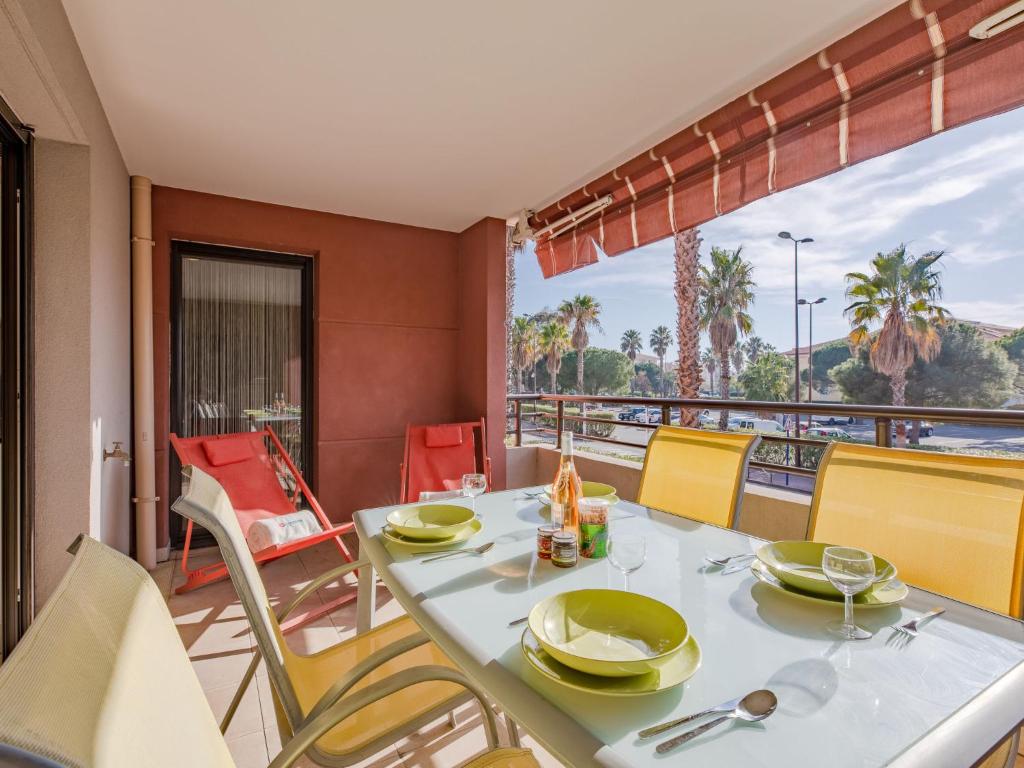 a dining room with a table and chairs on a balcony at Apartment Santa Monica-1 by Interhome in Fréjus