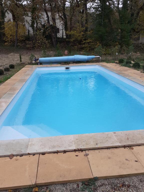 ein großer Pool mit blauem Wasser im Hof in der Unterkunft Un coin de campagne in Le Puy-Sainte-Réparade