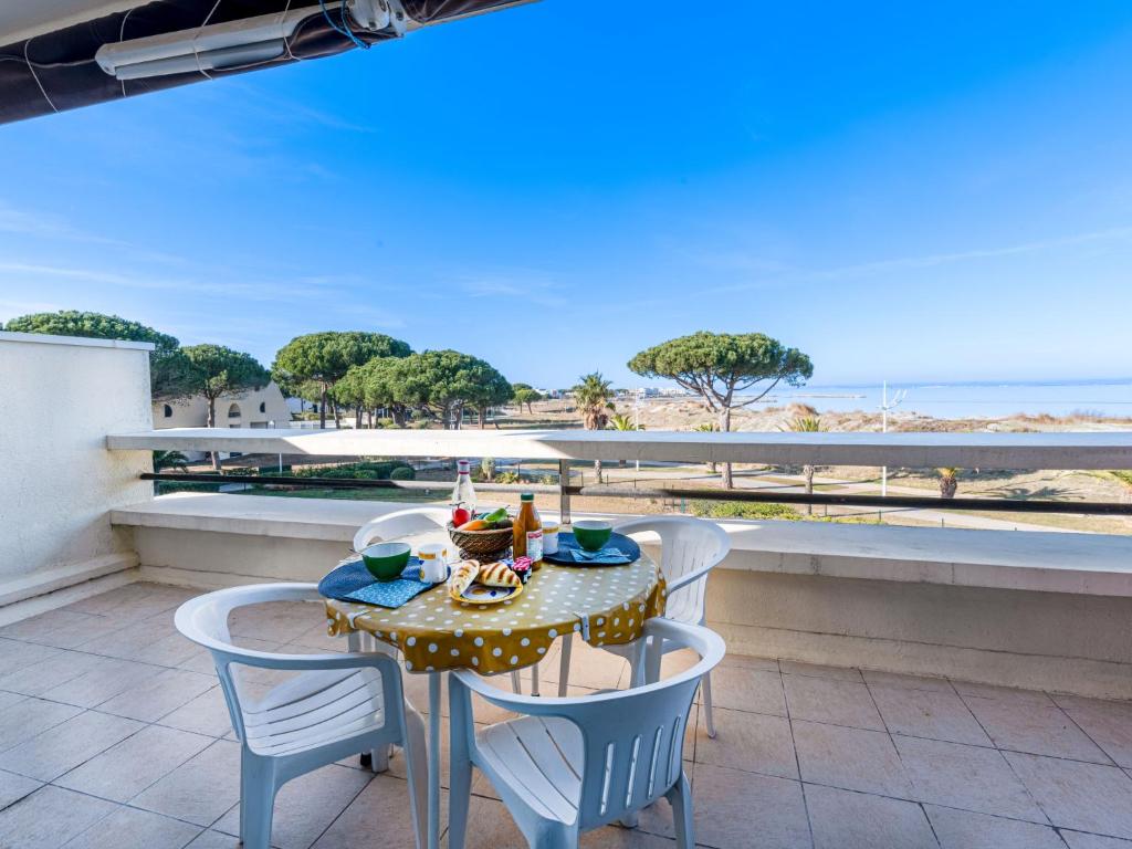 une table et des chaises sur un balcon avec vue sur l'océan dans l'établissement Apartment Le Serpent de Mer-2 by Interhome, au Grau-du-Roi