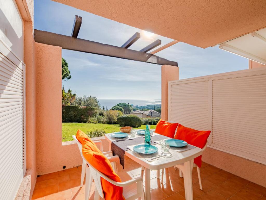 d'une salle à manger avec une table, des chaises et une fenêtre. dans l'établissement Apartment Les Coteaux de la Nartelle-3 by Interhome, à Sainte-Maxime