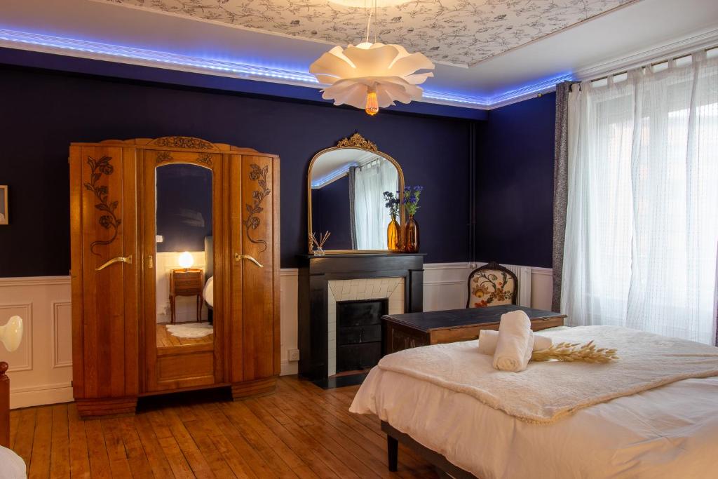 um quarto azul com uma cama e um espelho em Cosy Art Gallery em Reims