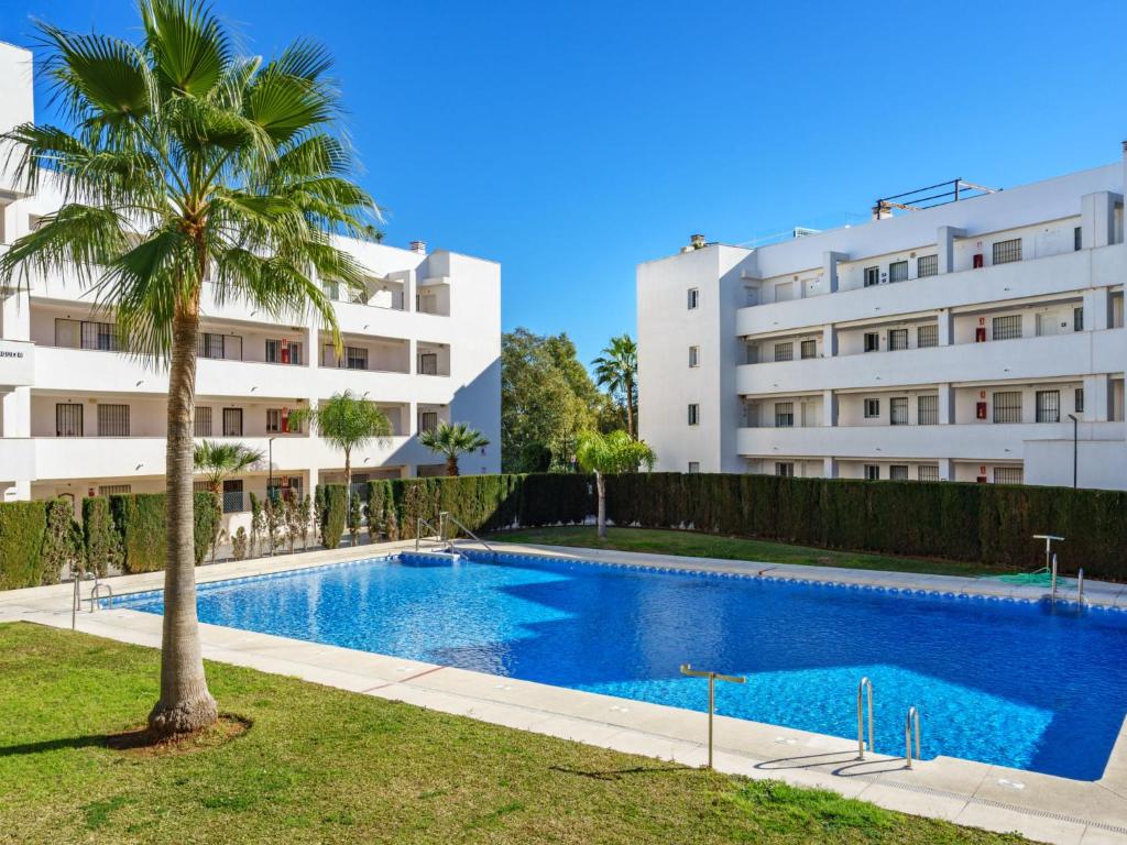 a palm tree in front of a building at Apartment Angel Blanco by Interhome in La Cala de Mijas
