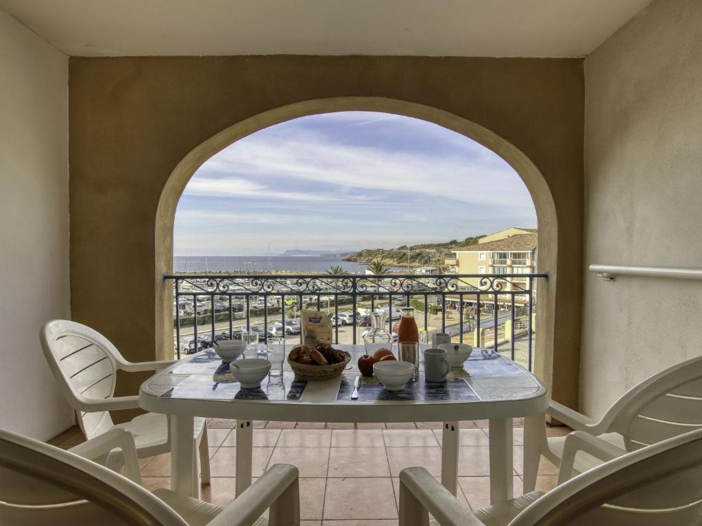 a table on a balcony with a view of the ocean at Apartment Les Rivages de Coudoulière-10 by Interhome in Six-Fours-les-Plages