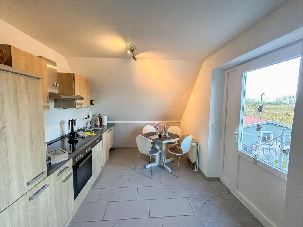 eine kleine Küche mit einem Tisch und einem Fenster in der Unterkunft Apartment Dori by Interhome in Westerholt