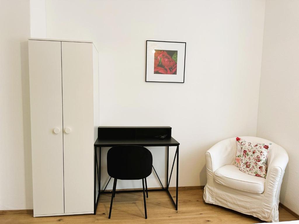 バート・ヴィルトバートにあるGästehaus Kühnleのデスクと椅子、キャビネットが備わる客室です。