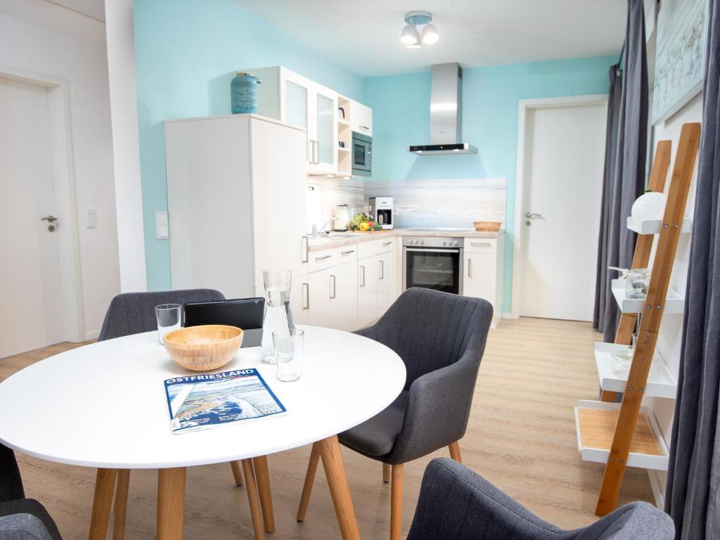 Una cocina y un comedor con una mesa y sillas blancas. en Apartment Ankerplatz by Interhome, en Norddeich