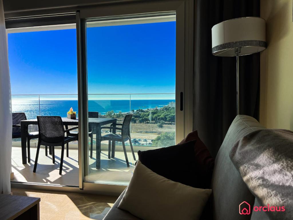 een woonkamer met uitzicht op een tafel en stoelen bij Calma y Relax en el Mediterráneo in Cabanes