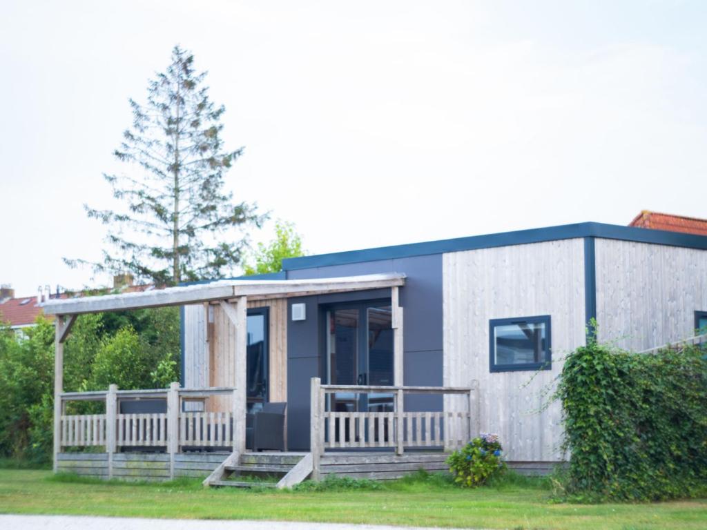 a tiny house with a porch and a fence at Holiday Home Natuurlijk de Veenhoop by Interhome in De Veenhoop