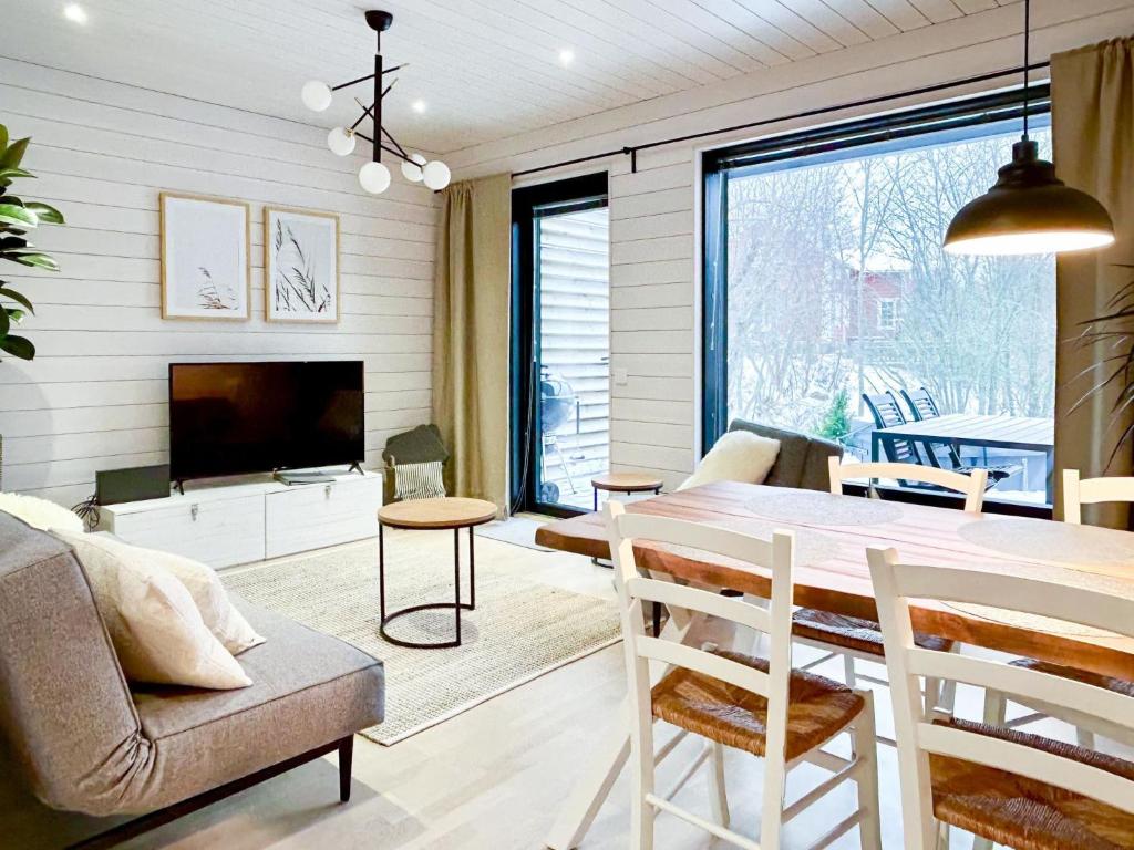 een woonkamer met een eettafel en een televisie bij Holiday Home Kasnäs marina b 15 by Interhome in Kasnäs