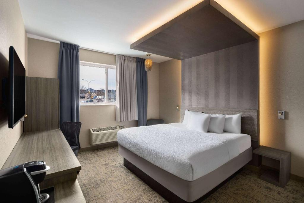 a hotel room with a bed and a window at Ramada by Wyndham Bronx in Bronx