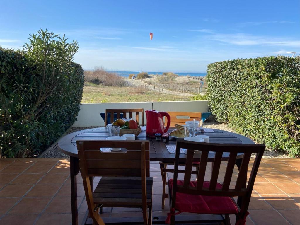 une table et des chaises sur une terrasse avec vue sur l'océan dans l'établissement Apartment Le Grand Large-3 by Interhome, au Grau-du-Roi