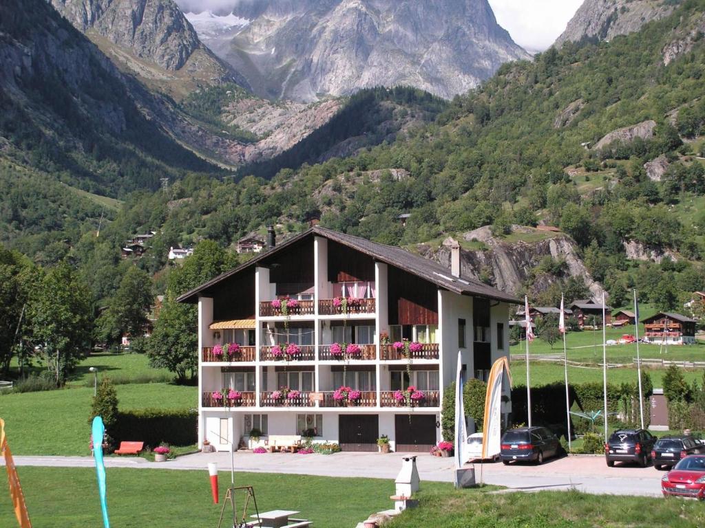 a building with balconies and flowers in front of a mountain at Apartment Casa Yolanda Mireille by Interhome in Fieschertal