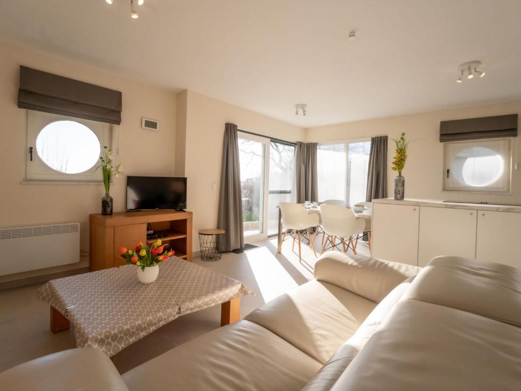 a living room with a white couch and a table at Apartment Athene 002 with parking by Interhome in Bredene