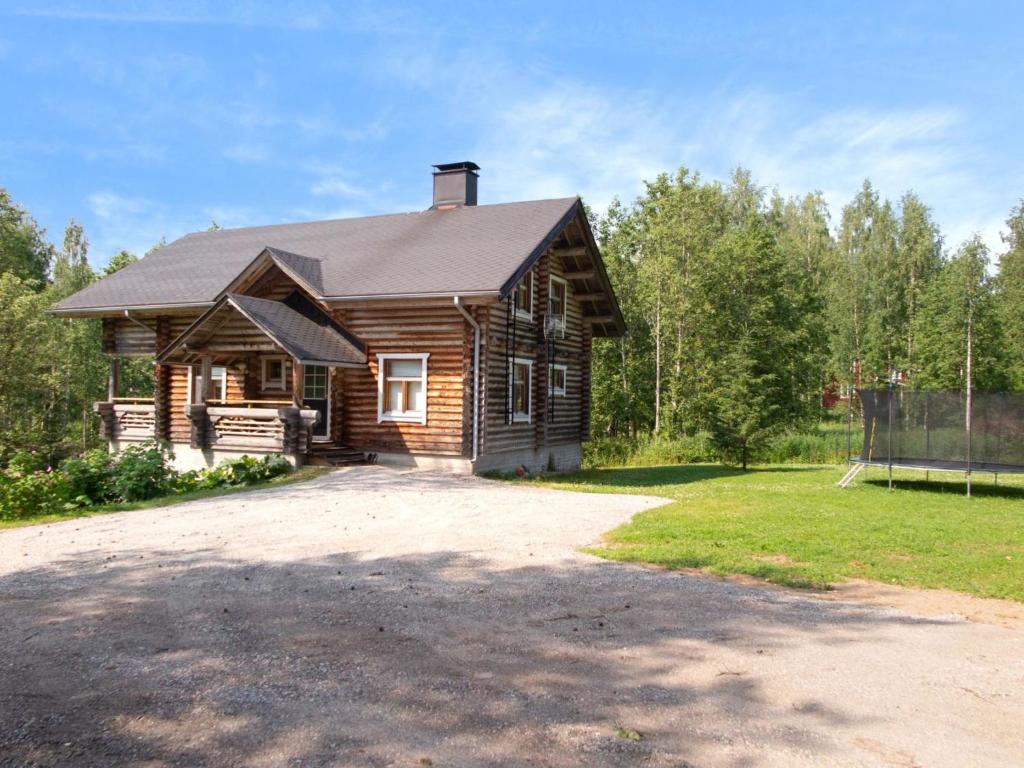 a log cabin with a driveway in front of it at Holiday Home Täperän torppa by Interhome in Nilsiä