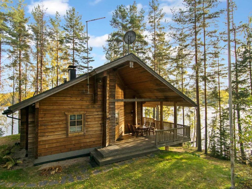 een blokhut in het bos met een terras bij Holiday Home Römpsi by Interhome in Iitti