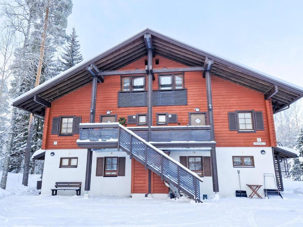 a large wooden house in the snow at Holiday Home Alppitalo sinitähti 9 apt 3 by Interhome in Tahkovuori