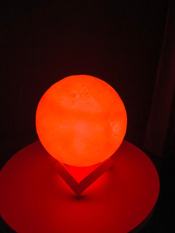 an orange lamp sitting on top of a red table at Relaxing Oasis in Tezpur