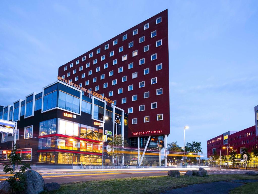 een gebouw op een straat in een stad 's nachts bij Mercure Hotel Amersfoort Centre in Amersfoort