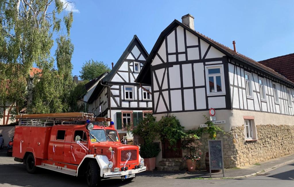 a red fire truck parked in front of a black and white building at Geibelhof in Karben