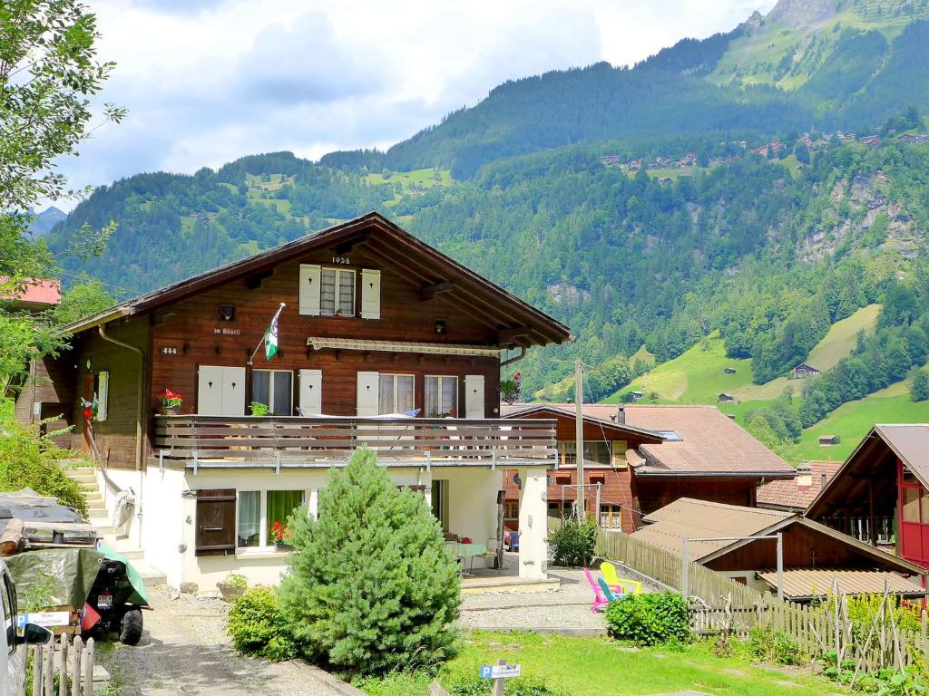 a house in the mountains with mountains in the background at Apartment Chalet im Gässli by Interhome in Lauterbrunnen