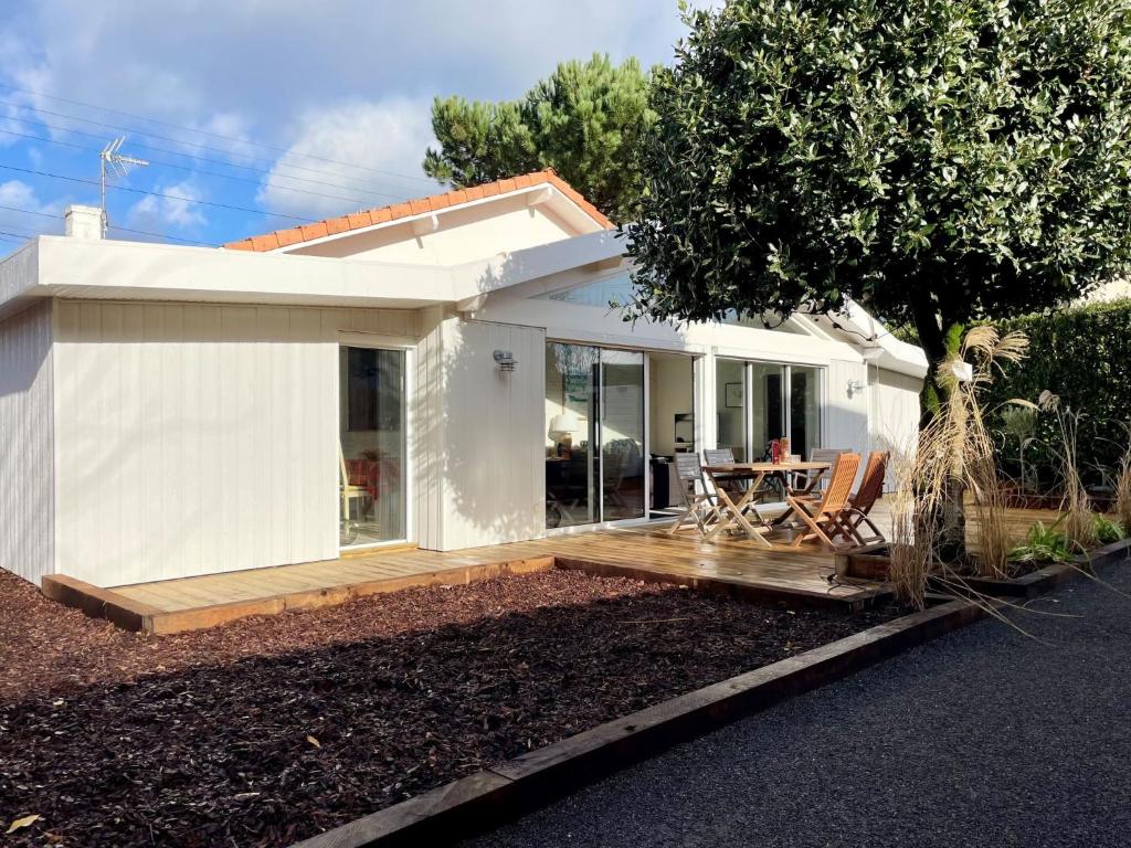 une maison blanche avec une terrasse et une table dans l'établissement Holiday Home La Petite Doussy by Interhome, à Arcachon