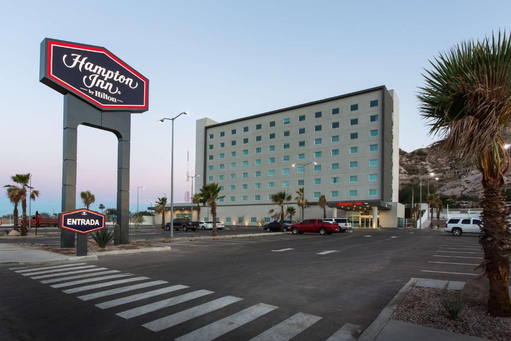 una señal para un hotel frente a un estacionamiento en Hampton Inn by Hilton Hermosillo, en Hermosillo