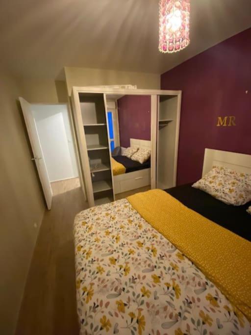 um pequeno quarto com uma cama e um espelho em T2 entier Chambre+Salon+Cuisine em Les Ulis