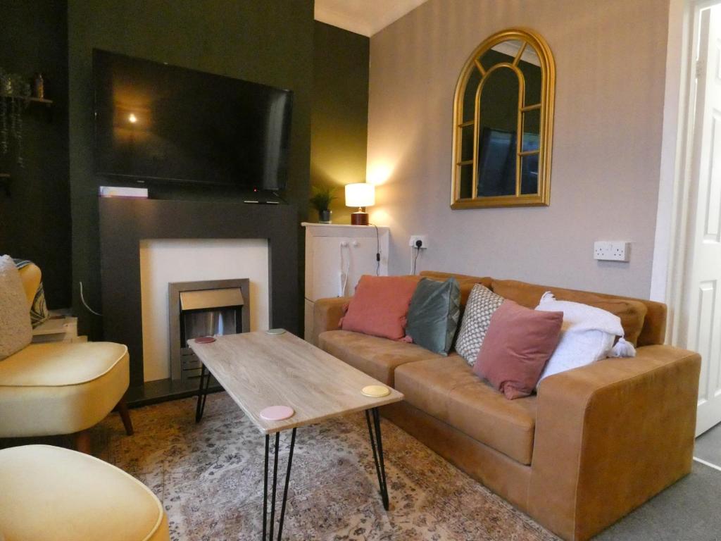 a living room with a couch and a fireplace at Comfy 3 Bedroom Cottage in a Calm Location in Abertillery