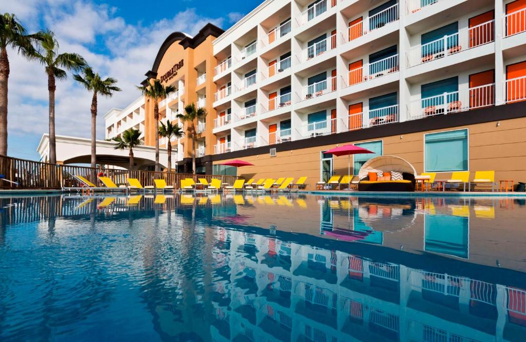 a swimming pool in front of a hotel at DoubleTree by Hilton Galveston Beach in Galveston