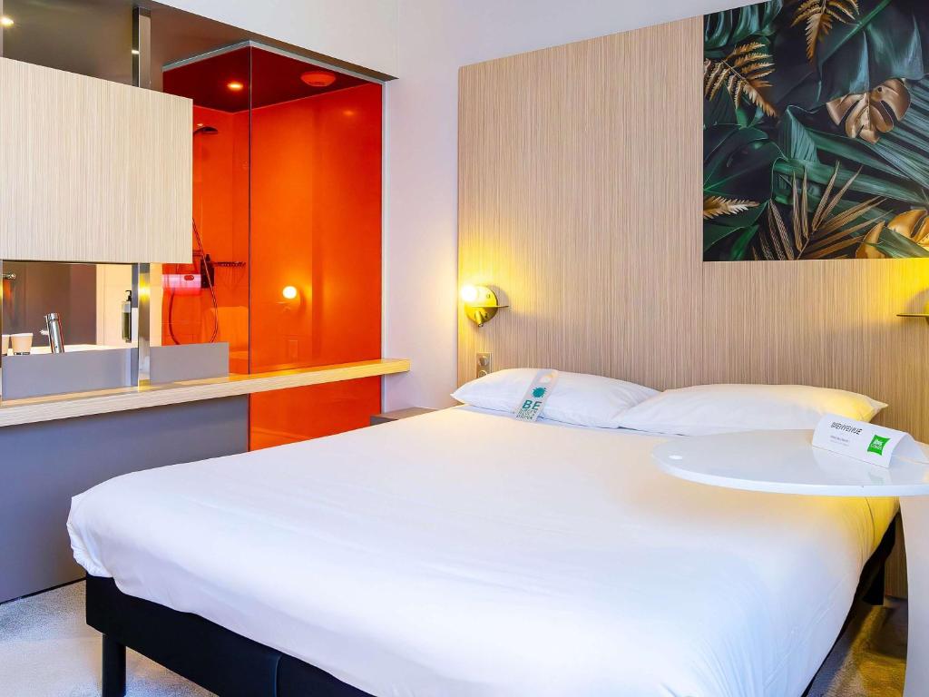 ein Schlafzimmer mit einem großen weißen Bett und einem Tisch in der Unterkunft ibis Styles Troyes Centre in Troyes